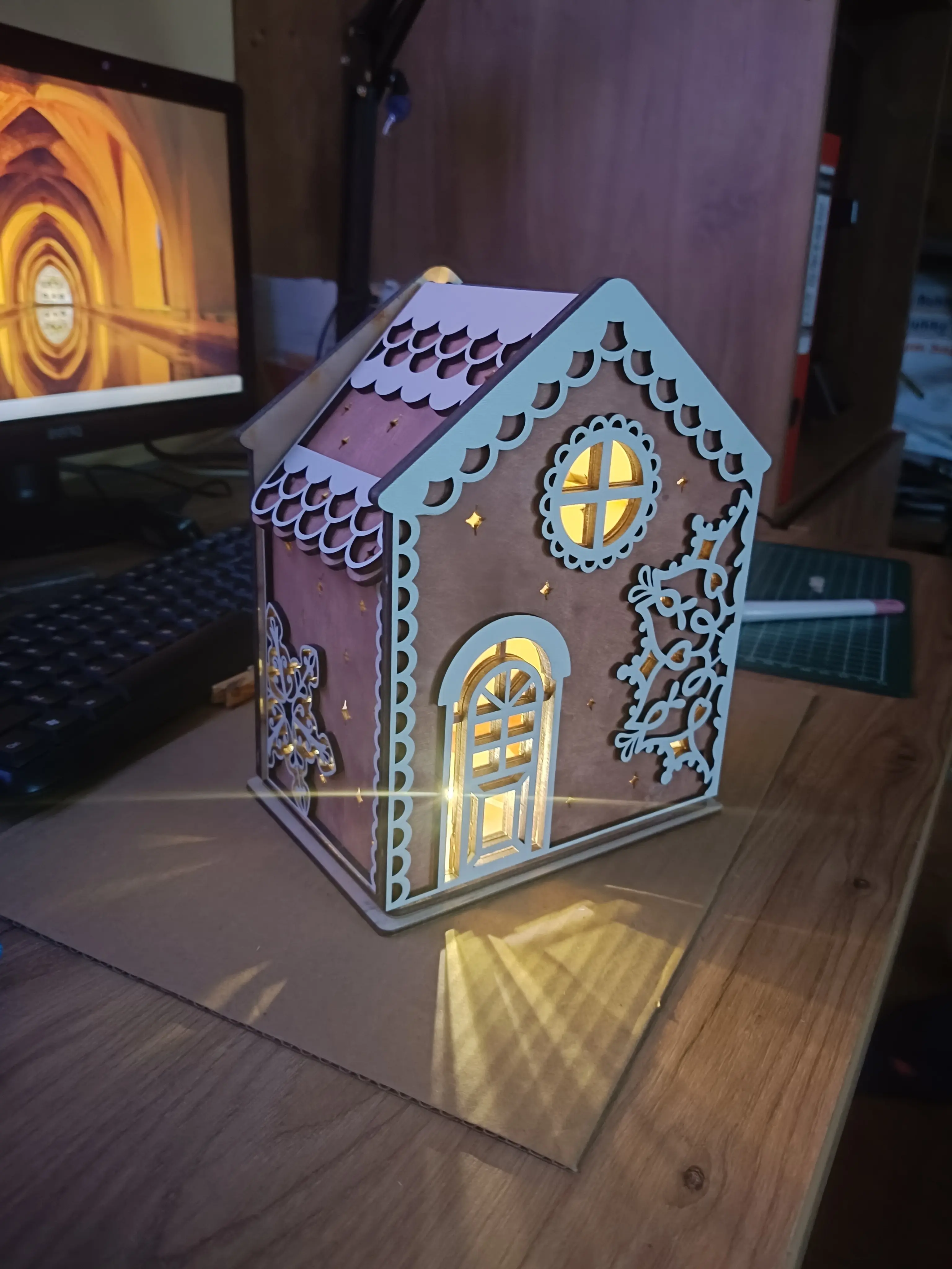 Drewniany domek świąteczny z podświetleniem LED, ozdobiony gwiazdkami i okienkami