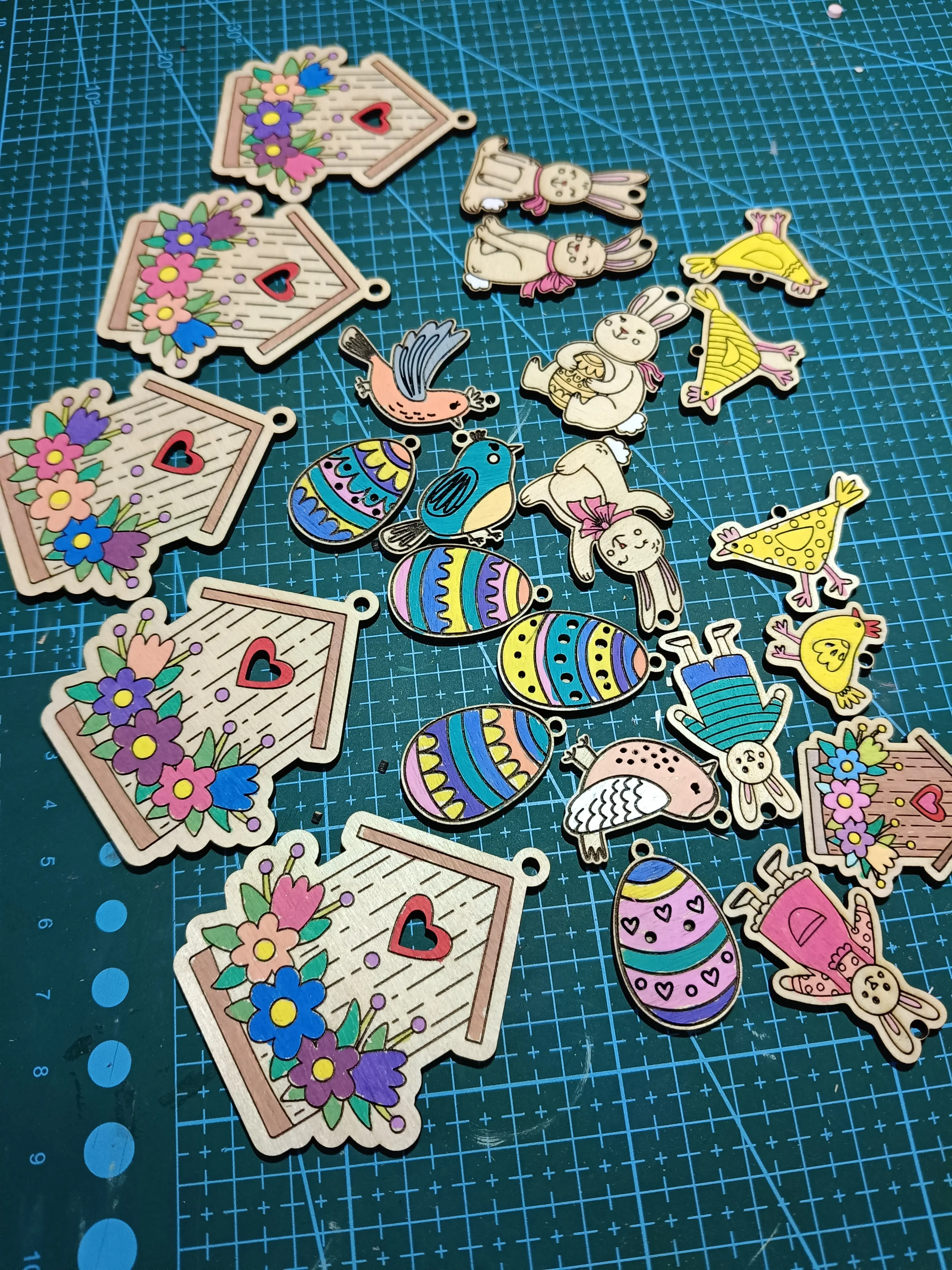 Kolorowe wycinanki wielkanocne z drewna i kartonu: pisanki, króliczki, ptaki, kurczaczki, owieczka i domki